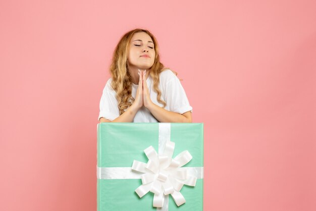 Vue de face jeune femme à l'intérieur de la boîte cadeau bleue