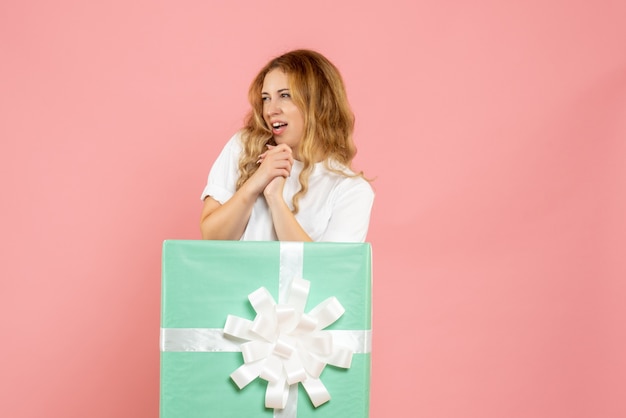 Vue de face jeune femme à l'intérieur de la boîte cadeau bleue