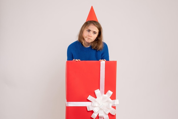 Vue de face jeune femme à l'intérieur de la boîte cadeau rouge