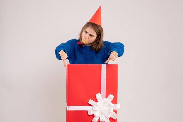 Vue de face jeune femme à l'intérieur de la boîte cadeau rouge