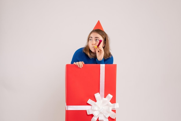 Vue de face jeune femme à l'intérieur de la boîte cadeau rouge