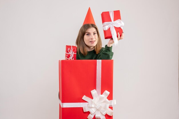 Vue de face jeune femme à l'intérieur de la boîte cadeau rouge