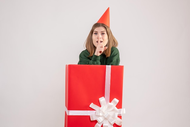 Vue de face jeune femme à l'intérieur de la boîte cadeau rouge