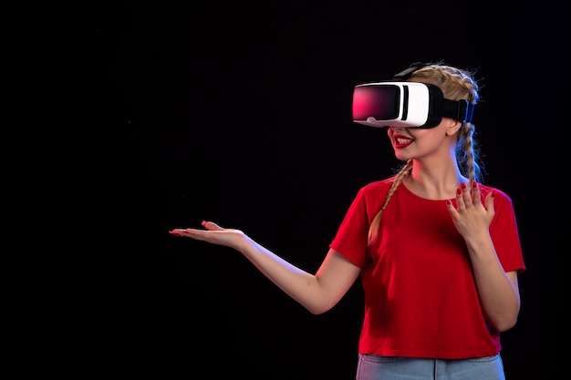 Vue de face d'une jeune femme jouant à la réalité virtuelle sur un jeu de fantaisie visuelle sombre