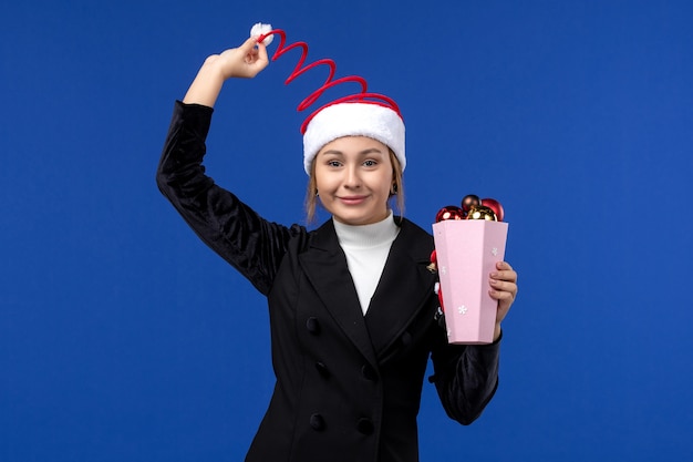 Vue de face jeune femme avec des jouets d'arbre sur le mur bleu émotion vacances nouvel an