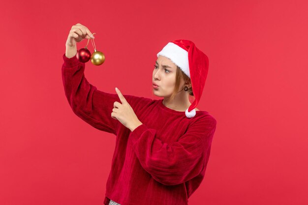 Vue de face jeune femme avec des jouets de Noël, émotion de Noël de vacances