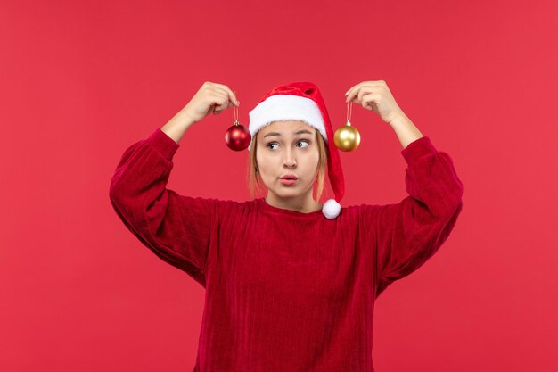 Vue de face jeune femme avec des jouets de noël, émotions de vacances de noël