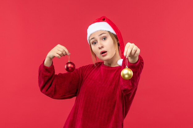 Vue de face jeune femme avec des jouets de Noël, vacances d'émotion de Noël