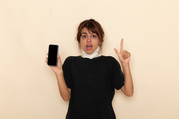 Vue de face jeune femme malade se sentant très malade et tenant le téléphone sur une surface blanche