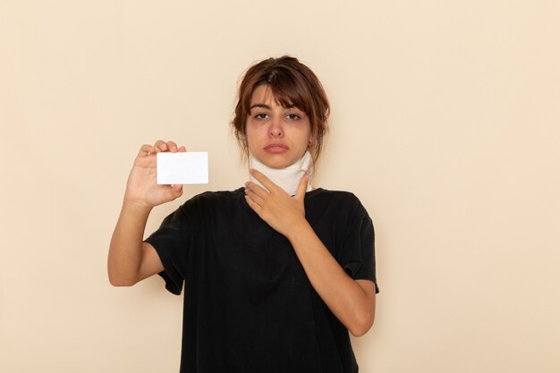 Vue de face jeune femme malade se sentir malade tenant une carte blanche sur une surface blanche légère