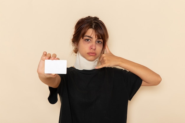 Photo gratuite vue de face jeune femme malade se sentir malade tenant une carte blanche sur une surface blanche