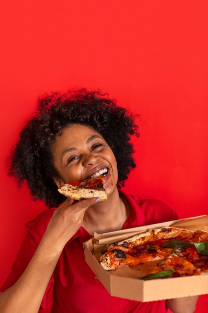 Vue de face jeune femme mangeant une délicieuse pizza
