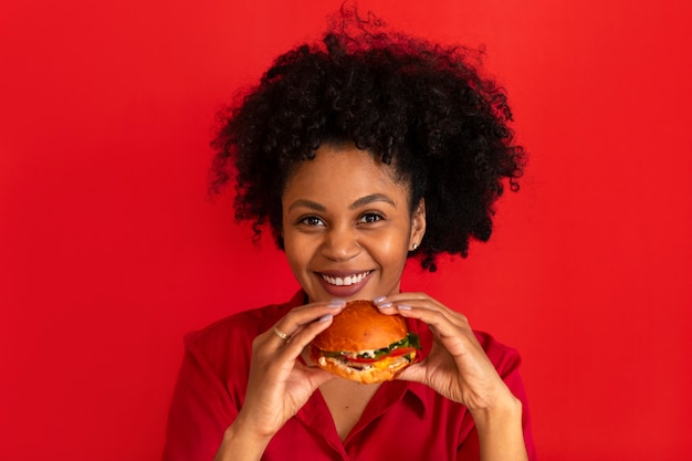 Photo gratuite vue de face jeune femme mangeant un hamburger