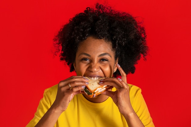 Photo gratuite vue de face jeune femme mangeant un sandwich