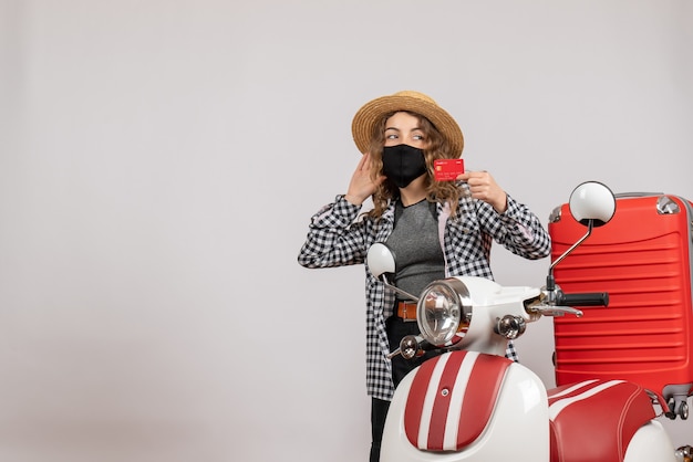 Vue De Face Jeune Femme Avec Masque Noir Tenant Une Carte Debout Près D'un Cyclomoteur Rouge