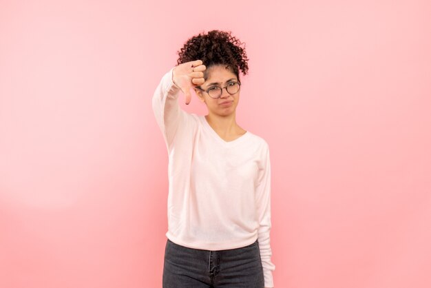 Vue de face de la jeune femme mécontente sur mur rose