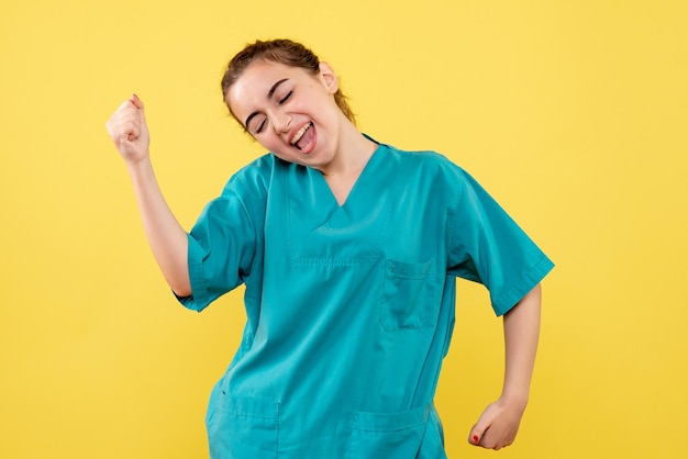 Photo gratuite vue de face de la jeune femme médecin en chemise médicale sur mur jaune