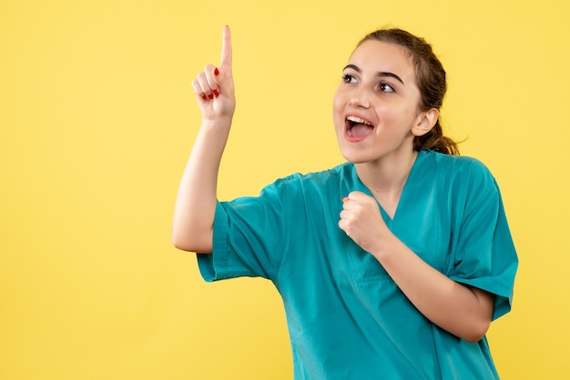 Vue de face jeune femme médecin en costume médical sur fond jaune