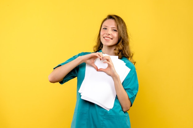 Vue de face jeune femme médecin envoi d'amour sur l'espace jaune