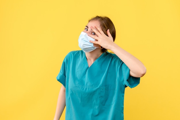 Vue de face de la jeune femme médecin en masque