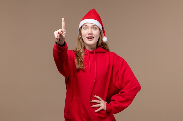 Vue de face jeune femme montrant le nombre sur fond brun émotion vacances de Noël