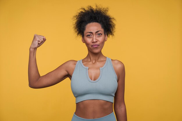 Vue de face d'une jeune femme montrant ses biceps