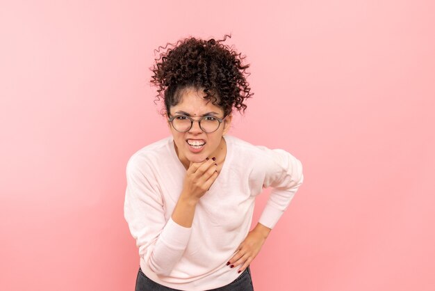 Photo gratuite vue de face de la jeune femme sur le mur rose