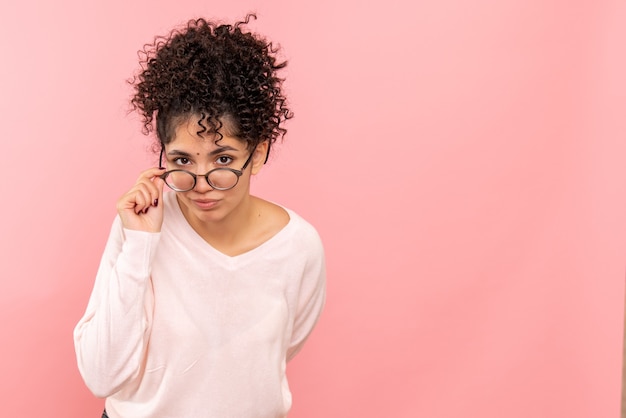 Vue de face de la jeune femme sur le mur rose