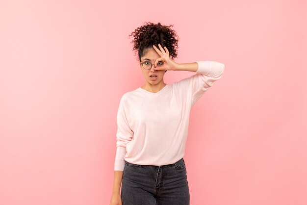 Vue de face de la jeune femme sur le mur rose