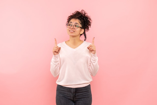 Vue de face de la jeune femme sur le mur rose