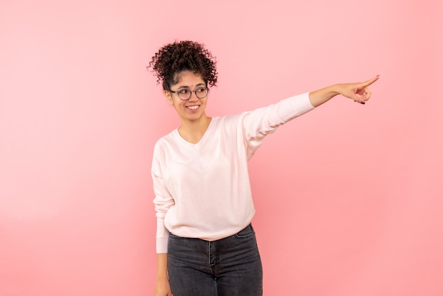 Photo gratuite vue de face de la jeune femme sur le mur rose