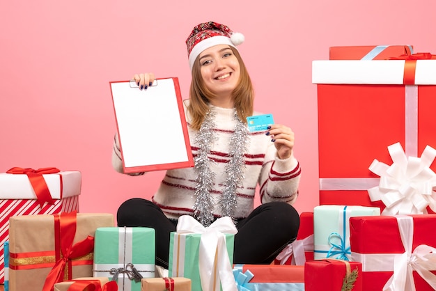 Vue de face jeune femme avec note de fichier et carte bancaire