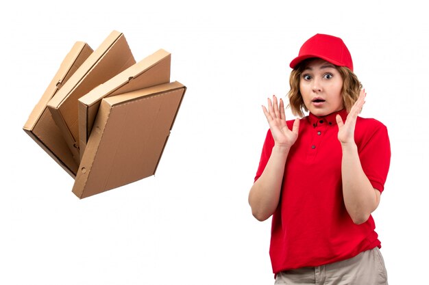 Une vue de face jeune femme ouvrière de messagerie du service de livraison de nourriture peur des boîtes de pizza jetées sur blanc