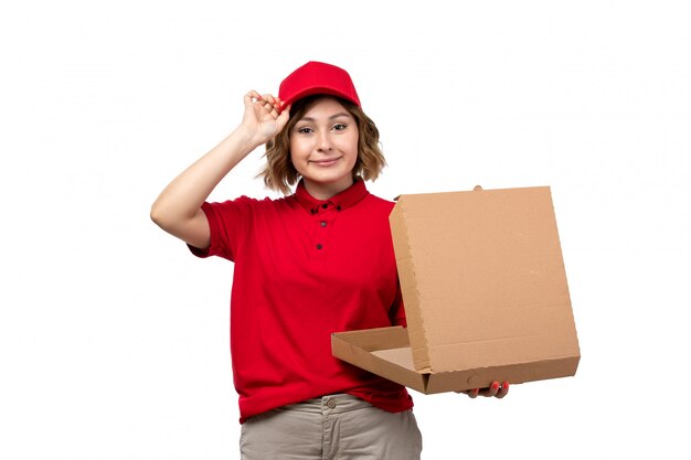 Une vue de face jeune femme ouvrière de messagerie de service de livraison de nourriture tenant une boîte à pizza vide sur blanc
