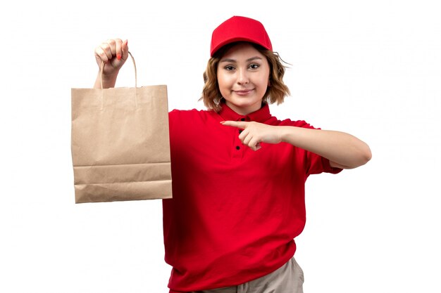 Une vue de face jeune femme ouvrière de messagerie de service de livraison de nourriture tenant le paquet de livraison de nourriture souriant sur blanc