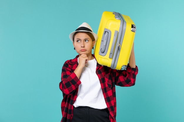 Vue de face jeune femme partant en vacances avec son gros sac en pensant à l'espace bleu