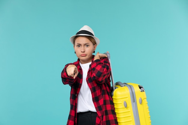 Vue de face jeune femme partant en vacances avec son sac jaune sur l'espace bleu