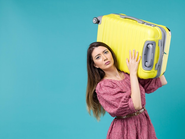 Vue de face jeune femme partant en vacances avec son sac jaune sur le fond bleu voyage d'été voyage humain femme mer