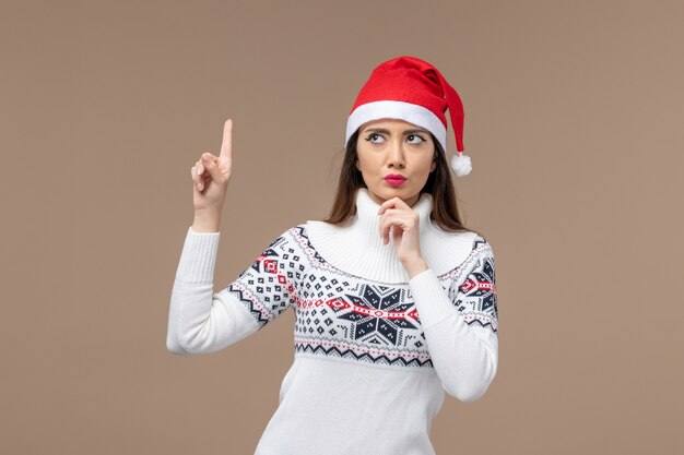 Vue de face jeune femme pensant sur fond brun émotion de Noël nouvel an