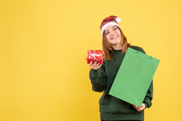 Vue de face jeune femme avec peu de cadeau et de shopping package