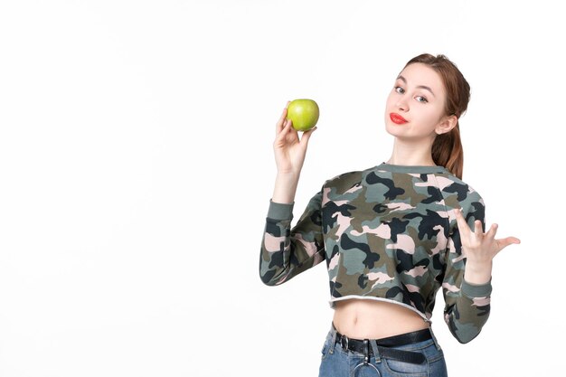 Vue de face jeune femme avec pomme verte sur blanc