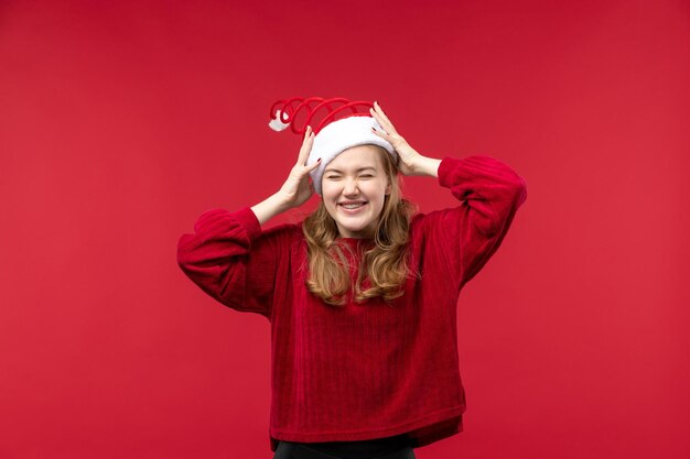 Vue de face jeune femme portant un bonnet de Noel rouge, vacances de Noël