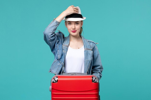 Vue de face jeune femme portant un chapeau se prépare pour le voyage sur l'espace bleu