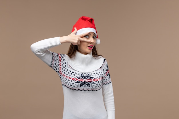 Vue de face jeune femme posant sur fond marron émotion Noël nouvel an