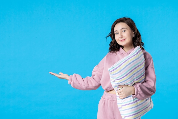 Vue de face jeune femme en pyjama rose avec oreiller sur le lit de couleur bleu nuit reste rêves femme sommeil insomnie