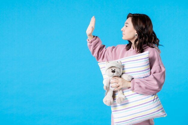 Vue de face jeune femme en pyjama rose parler à quelqu'un sur bleu fête insomnie lit nuit rêve repos sommeil