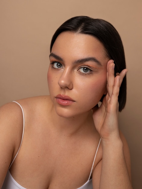 Vue de face jeune femme qui pose en studio