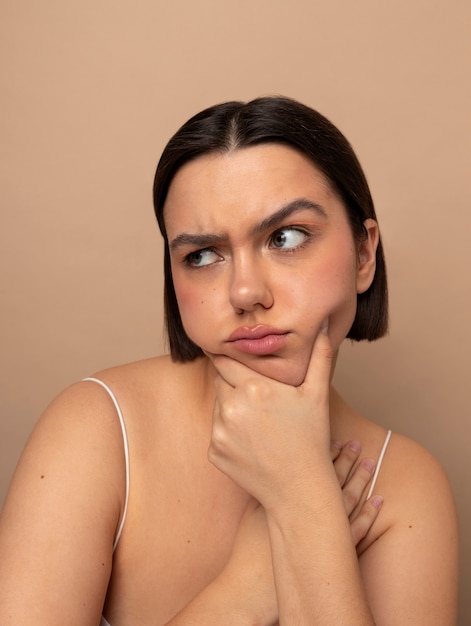 Photo gratuite vue de face jeune femme qui pose en studio