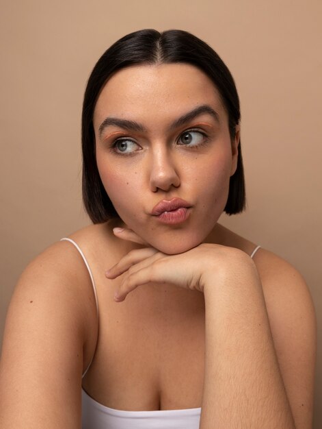 Vue de face jeune femme qui pose en studio