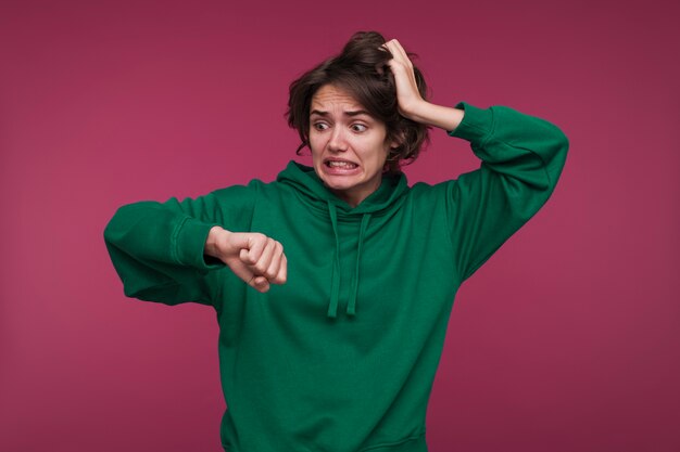 Vue de face d'une jeune femme regardant sa montre